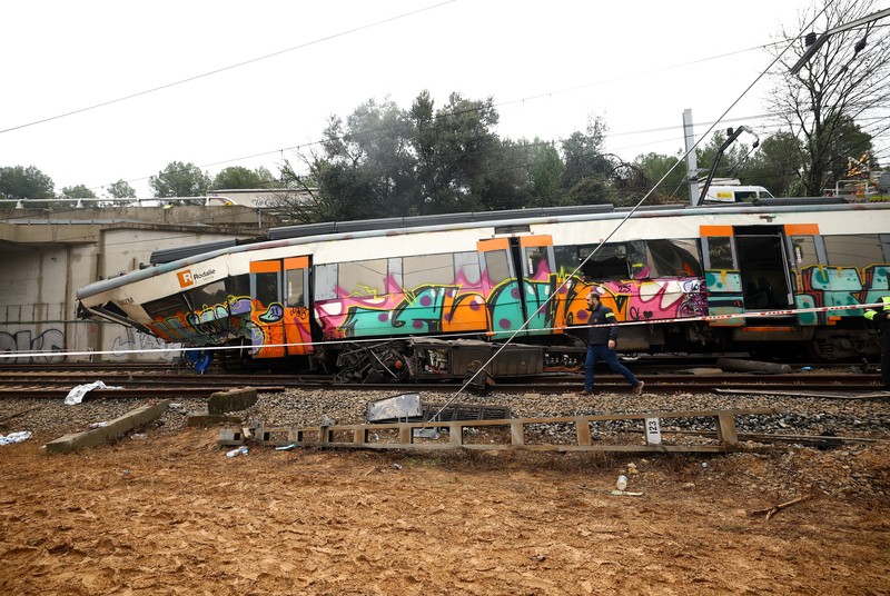 Polisi dan petugas pemadam kebakaran memeriksa lokasi kecelakaan kereta komuter, setelah dinding pembatas ambruk ke rel akibat hujan lebat, menewaskan masinis dan melukai beberapa orang, di Gelida, dekat Barcelona, ​​Spanyol, 21 Januari 2026. (REUTERS/Albert Gea)