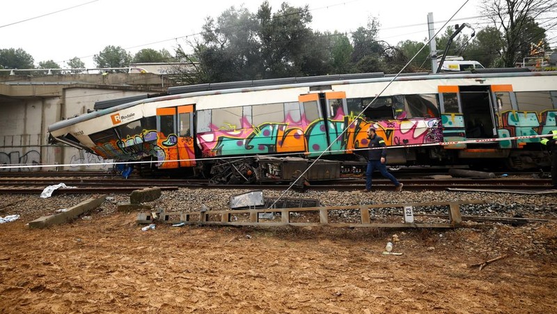 Polisi dan petugas pemadam kebakaran memeriksa lokasi kecelakaan kereta komuter, setelah dinding pembatas ambruk ke rel akibat hujan lebat, menewaskan masinis dan melukai beberapa orang, di Gelida, dekat Barcelona, ​​Spanyol, 21 Januari 2026. (REUTERS/Albert Gea)