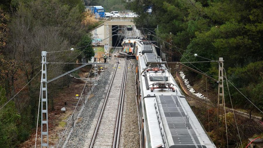 Polisi dan petugas pemadam kebakaran memeriksa lokasi kecelakaan kereta komuter, setelah dinding pembatas ambruk ke rel akibat hujan lebat, menewaskan masinis dan melukai beberapa orang, di Gelida, dekat Barcelona, ​​Spanyol, 21 Januari 2026. (REUTERS/Albert Gea)