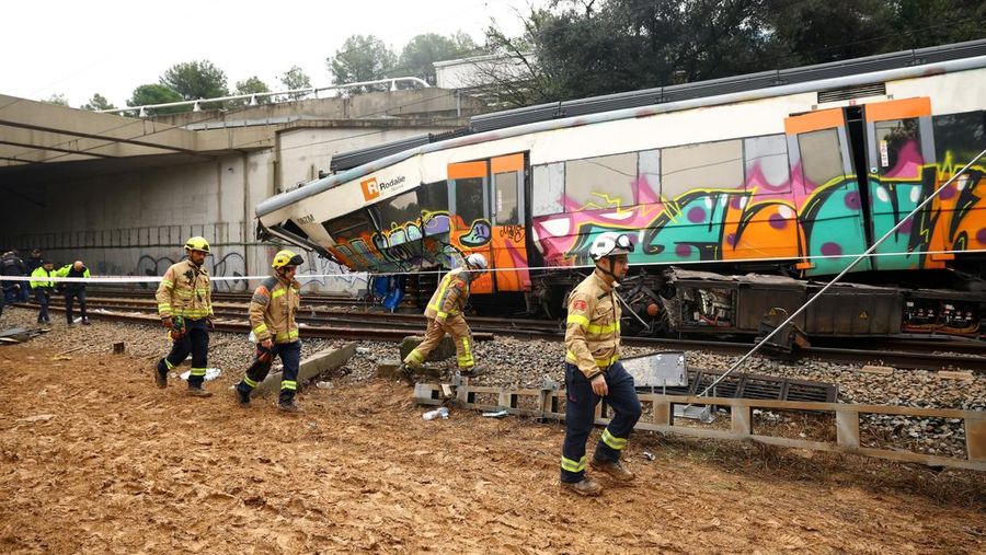 Polisi dan petugas pemadam kebakaran memeriksa lokasi kecelakaan kereta komuter, setelah dinding pembatas ambruk ke rel akibat hujan lebat, menewaskan masinis dan melukai beberapa orang, di Gelida, dekat Barcelona, ​​Spanyol, 21 Januari 2026. (REUTERS/Albert Gea)