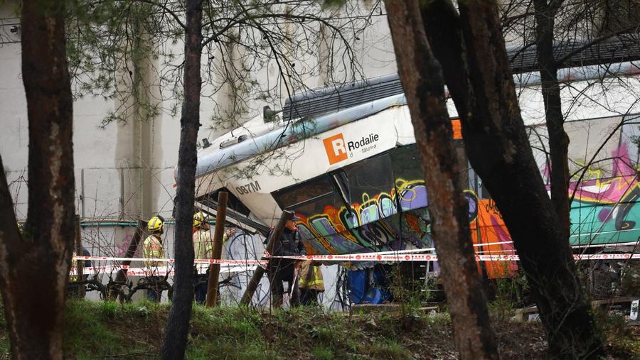 Polisi dan petugas pemadam kebakaran memeriksa lokasi kecelakaan kereta komuter, setelah dinding pembatas ambruk ke rel akibat hujan lebat, menewaskan masinis dan melukai beberapa orang, di Gelida, dekat Barcelona, ​​Spanyol, 21 Januari 2026. (REUTERS/Albert Gea)