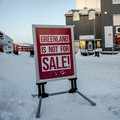 Warga berjalan melewati rambu yang dipasang di jalan di Nuuk, Greenland, Selasa, 20 Januari 2026. (Ritzau Scanpix/ Mads Claus Rasmussen via REUTERS)