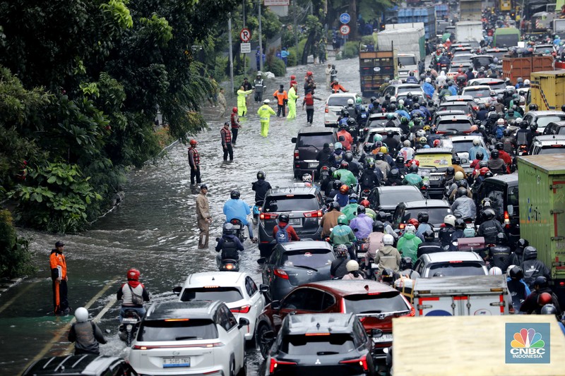 Hujan deras mengguyur Jakarta menyebabkan banjir menggenangi ruas jalan Panjaitan, tepatnya di lajur kiri dari arah Cawang menuju Kebon Nanas, Jakarta, Kamis (22/1/2026). (CNBC Indonesia/Tri Susilo)