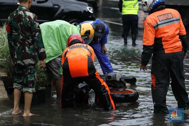 Hujan deras mengguyur Jakarta menyebabkan banjir menggenangi ruas jalan Panjaitan, tepatnya di lajur kiri dari arah Cawang menuju Kebon Nanas, Jakarta, Kamis (22/1/2026). (CNBC Indonesia/Tri Susilo)