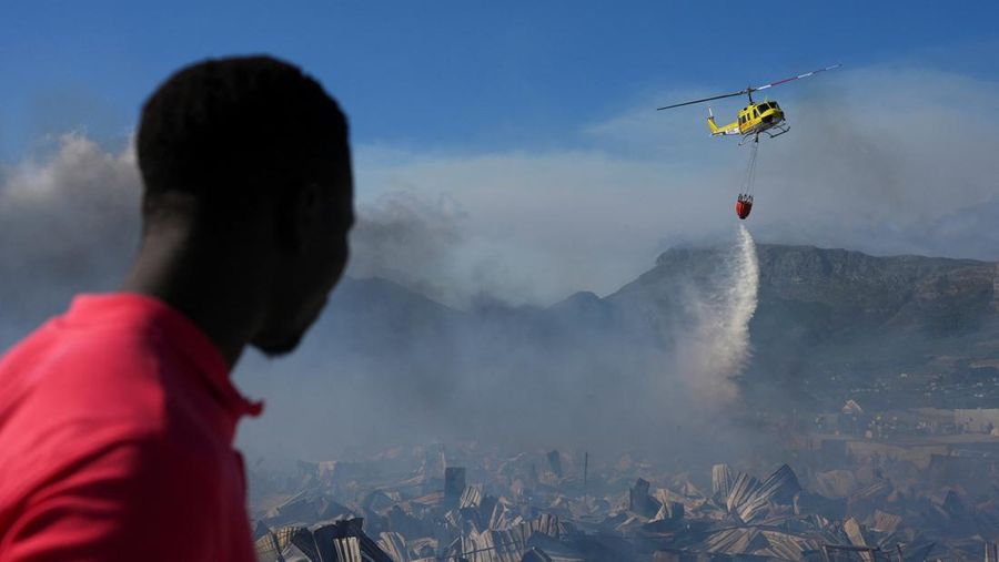 Seorang petugas pemadam kebakaran berdiri di samping kobaran api yang masih berlangsung di daerah Franschhoek, Cape Town, Afrika Selatan, 21 Januari 2026. (REUTERS/Esa Alexander)