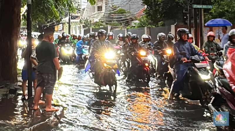 Sejumlah kendaraan melintasi Jalan DI Pandjaitan, Jakarta Timur yang hingga sore hari masih terendam banjir, menyebabkan arus lalu lintas di sekitar lokasi mengalami kemacetan, Kamis (22/1/2026). (CNBC Indonesia/Dara Randa)