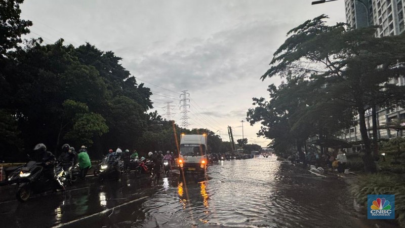 Sejumlah kendaraan melintasi Jalan DI Pandjaitan, Jakarta Timur yang hingga sore hari masih terendam banjir, menyebabkan arus lalu lintas di sekitar lokasi mengalami kemacetan, Kamis (22/1/2026). (CNBC Indonesia/Dara Randa)