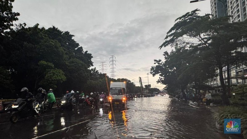 Sejumlah kendaraan melintasi Jalan DI Pandjaitan, Jakarta Timur yang hingga sore hari masih terendam banjir, menyebabkan arus lalu lintas di sekitar lokasi mengalami kemacetan, Kamis (22/1/2026). (CNBC Indonesia/Dara Randa)