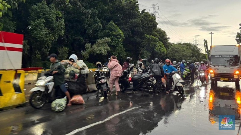 Sejumlah kendaraan melintasi Jalan DI Pandjaitan, Jakarta Timur yang hingga sore hari masih terendam banjir, menyebabkan arus lalu lintas di sekitar lokasi mengalami kemacetan, Kamis (22/1/2026). (CNBC Indonesia/Dara Randa)