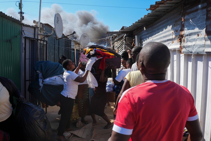 Seorang petugas pemadam kebakaran berdiri di samping kobaran api yang masih berlangsung di daerah Franschhoek, Cape Town, Afrika Selatan, 21 Januari 2026. (REUTERS/Esa Alexander)