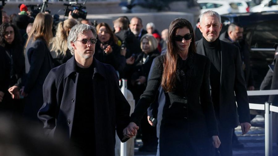 Anthony Souza, anak baptis mendiang perancang busana Valentino Garavani, dan para pengusung peti mati membawa peti jenazah Valentino Garavani, yang meninggal pada usia 93 tahun, di luar Basilika Santa Maria dari Para Malaikat dan Martir, selama upacara pemakaman, di Roma, Italia, 23 Januari 2026. (REUTERS/Yara Nardi)