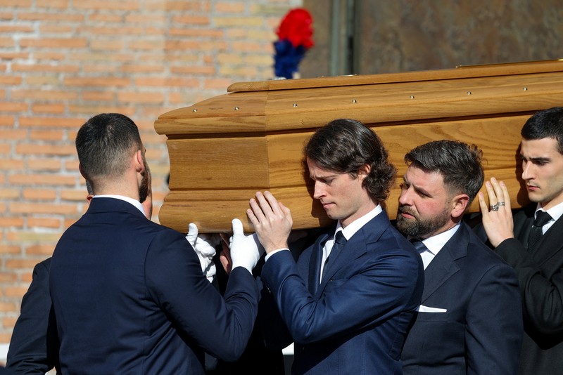 Anthony Souza, anak baptis mendiang perancang busana Valentino Garavani, dan para pengusung peti mati membawa peti jenazah Valentino Garavani, yang meninggal pada usia 93 tahun, di luar Basilika Santa Maria dari Para Malaikat dan Martir, selama upacara pemakaman, di Roma, Italia, 23 Januari 2026. (REUTERS/Yara Nardi)