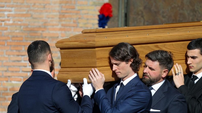 Anthony Souza, anak baptis mendiang perancang busana Valentino Garavani, dan para pengusung peti mati membawa peti jenazah Valentino Garavani, yang meninggal pada usia 93 tahun, di luar Basilika Santa Maria dari Para Malaikat dan Martir, selama upacara pemakaman, di Roma, Italia, 23 Januari 2026. (REUTERS/Yara Nardi)