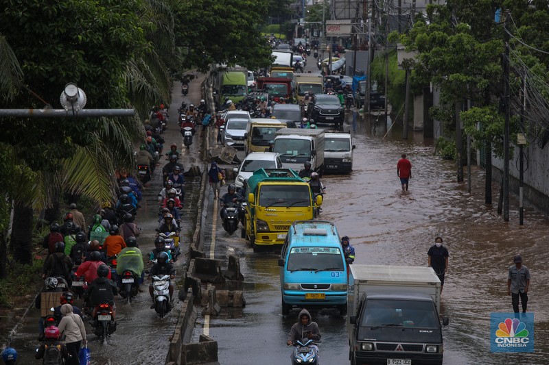Kendaraan melintas saat banjir melanda ruas Jalan Daan Mogot, Jakarta Barat, Jumat (23/1/2026). (CNBC Indonesia/Tri Susilo)
