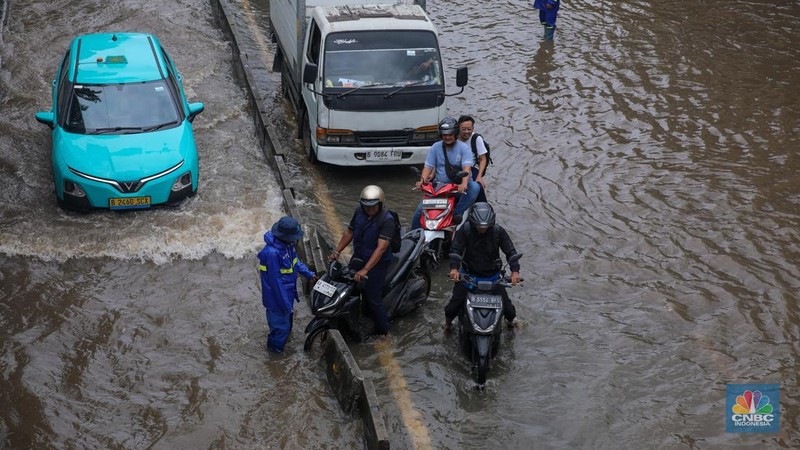 Kendaraan melintas saat banjir melanda ruas Jalan Daan Mogot, Jakarta Barat, Jumat (23/1/2026). (CNBC Indonesia/Tri Susilo)