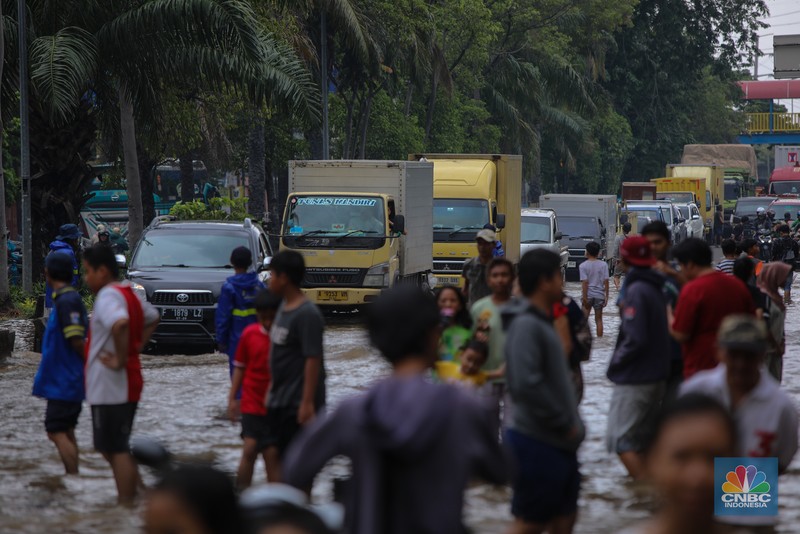 Kendaraan melintas saat banjir melanda ruas Jalan Daan Mogot, Jakarta Barat, Jumat (23/1/2026). (CNBC Indonesia/Tri Susilo)