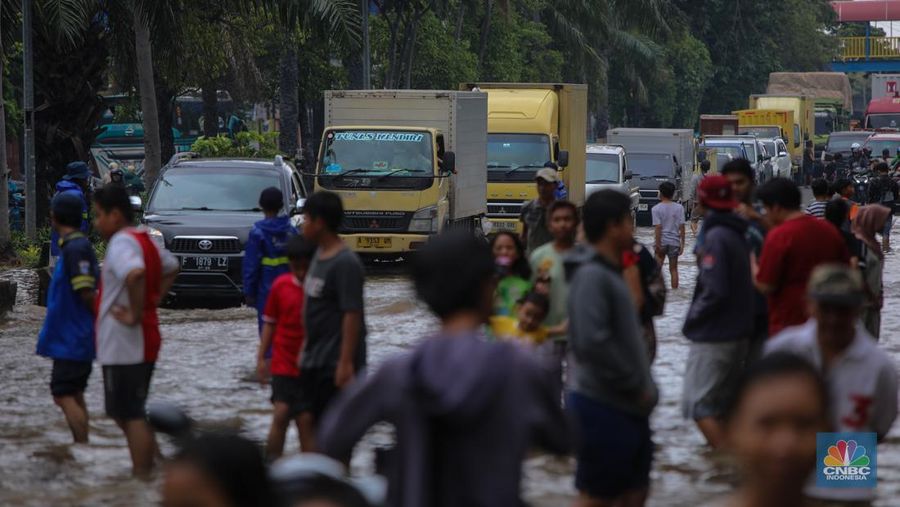 Kendaraan melintas saat banjir melanda ruas Jalan Daan Mogot, Jakarta Barat, Jumat (23/1/2026). (CNBC Indonesia/Tri Susilo)