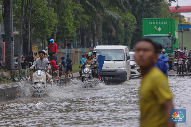 Kendaraan melintas saat banjir melanda ruas Jalan Daan Mogot, Jakarta Barat, Jumat (23/1/2026). (CNBC Indonesia/Tri Susilo)