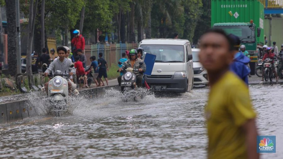 Kendaraan melintas saat banjir melanda ruas Jalan Daan Mogot, Jakarta Barat, Jumat (23/1/2026). (CNBC Indonesia/Tri Susilo)