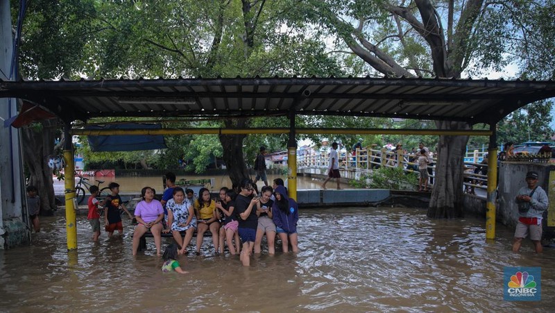 Kendaraan melintas saat banjir melanda ruas Jalan Daan Mogot, Jakarta Barat, Jumat (23/1/2026). (CNBC Indonesia/Tri Susilo)