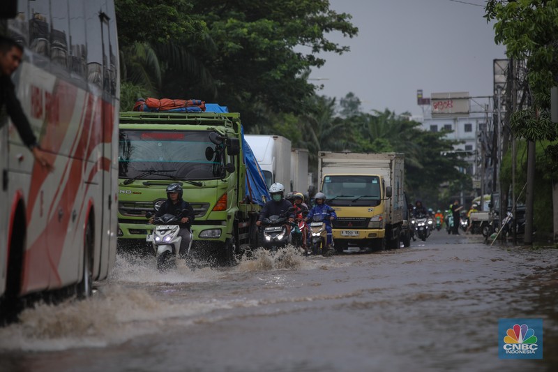 Kendaraan melintas saat banjir melanda ruas Jalan Daan Mogot, Jakarta Barat, Jumat (23/1/2026). (CNBC Indonesia/Tri Susilo)
