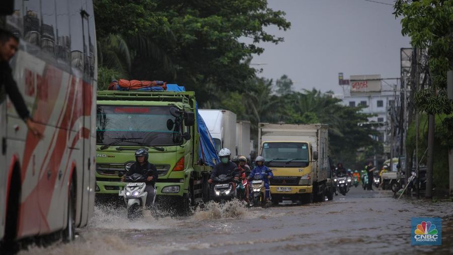 Kendaraan melintas saat banjir melanda ruas Jalan Daan Mogot, Jakarta Barat, Jumat (23/1/2026). (CNBC Indonesia/Tri Susilo)