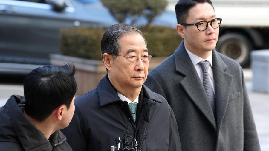 Mantan Perdana Menteri Korea Selatan Han Duck-soo (C) tiba di Pengadilan Distrik Pusat Seoul untuk sidang vonis pertamanya dalam kasus pemberontakan pada 21 Januari 2026 di Seoul, Korea Selatan. (Chung Sung-Jun/Pool via REUTERS)