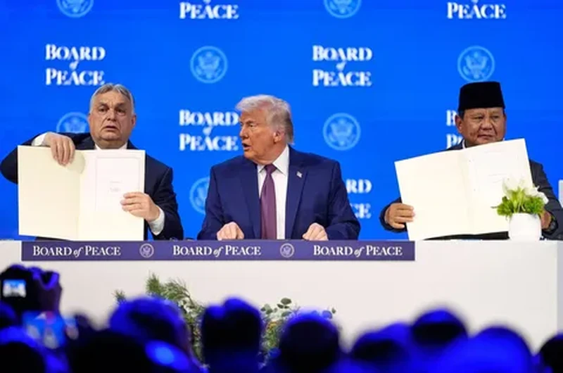 Presiden Prabowo Subianto dan Perdana Menteri Hungaria Viktor Orban (kiri) memegang piagam pendirian yang telah ditandatangani di samping Presiden AS Donald Trump pada pertemuan di Davos, Swiss, Kamis (22/01/2026). (AFP/ Mandel Ngan)