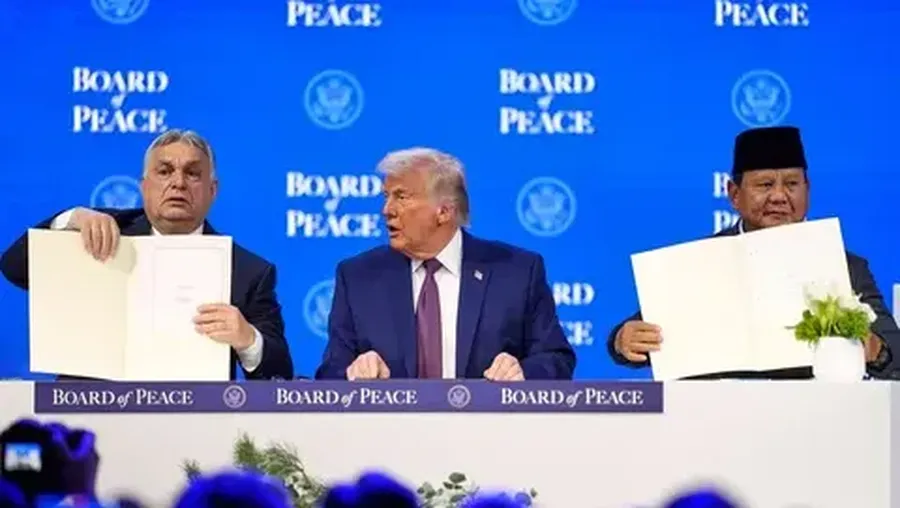 Presiden Prabowo Subianto dan Perdana Menteri Hungaria Viktor Orban (kiri) memegang piagam pendirian yang telah ditandatangani di samping Presiden AS Donald Trump pada pertemuan di Davos, Swiss, Kamis (22/01/2026). (AFP/ Mandel Ngan)