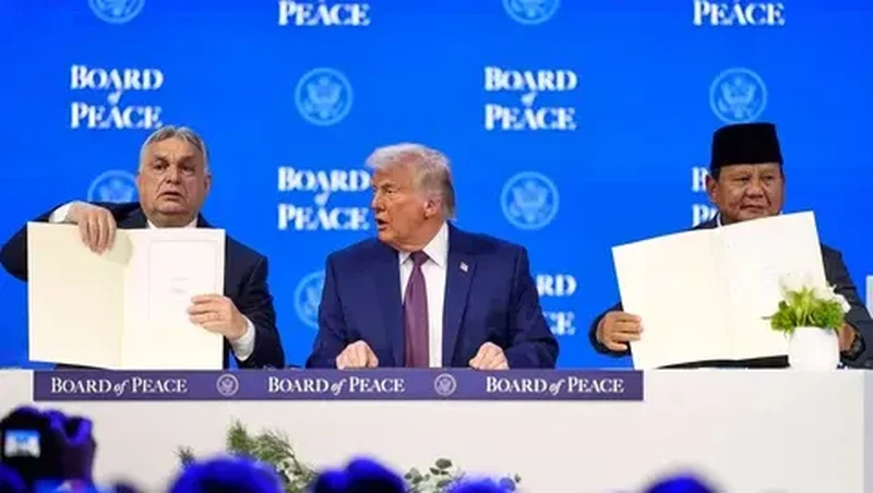 Presiden Prabowo Subianto dan Perdana Menteri Hungaria Viktor Orban (kiri) memegang piagam pendirian yang telah ditandatangani di samping Presiden AS Donald Trump pada pertemuan di Davos, Swiss, Kamis (22/01/2026). (AFP/ Mandel Ngan)