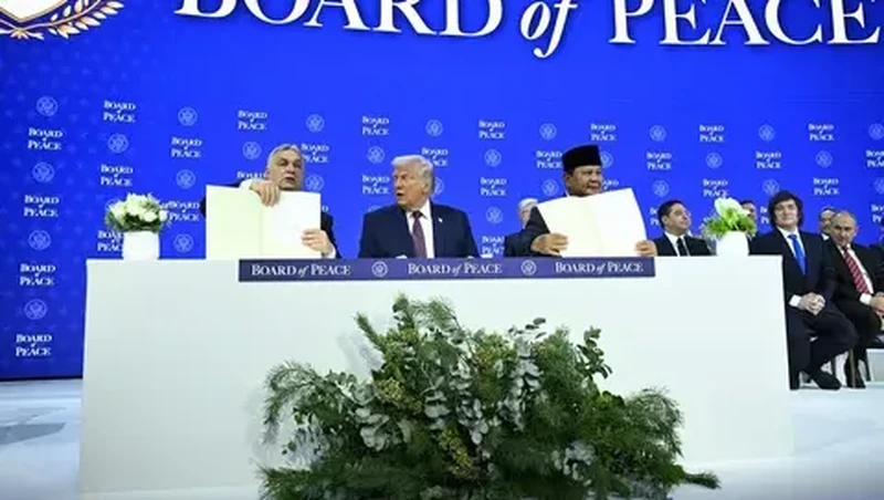 Presiden Prabowo Subianto dan Perdana Menteri Hungaria Viktor Orban (kiri) memegang piagam pendirian yang telah ditandatangani di samping Presiden AS Donald Trump pada pertemuan di Davos, Swiss, Kamis (22/01/2026). (AFP/ Mandel Ngan)