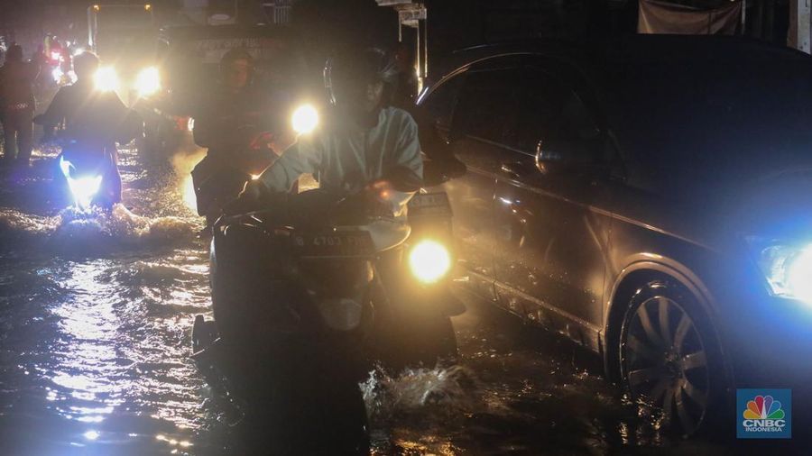 Sejumlah kendaraan terjebak kemacetan panjang di Jalan Raya HM Martono, Bekasi, Jawa Barat, akibat banjir yang merendam wilayah Jatimulya, Kamis (22/1/2026) malam. Genangan air membuat ruas jalan tersebut sempat tidak dapat dilalui kendaraan. (CNBC Indonesia/Tias Budiarto)