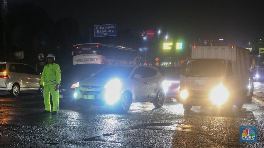 Sejumlah kendaraan terjebak kemacetan panjang di Jalan Raya HM Martono, Bekasi, Jawa Barat, akibat banjir yang merendam wilayah Jatimulya, Kamis (22/1/2026) malam. Genangan air membuat ruas jalan tersebut sempat tidak dapat dilalui kendaraan. (CNBC Indonesia/Tias Budiarto)