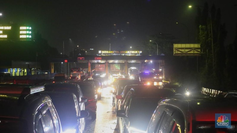 Sejumlah kendaraan terjebak kemacetan panjang di Jalan Raya HM Martono, Bekasi, Jawa Barat, akibat banjir yang merendam wilayah Jatimulya, Kamis (22/1/2026) malam. Genangan air membuat ruas jalan tersebut sempat tidak dapat dilalui kendaraan. (CNBC Indonesia/Tias Budiarto)