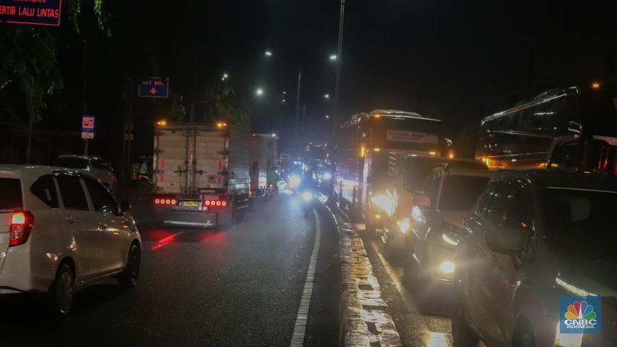 Sejumlah kendaraan terjebak kemacetan panjang di Jalan Raya HM Martono, Bekasi, Jawa Barat, akibat banjir yang merendam wilayah Jatimulya, Kamis (22/1/2026) malam. Genangan air membuat ruas jalan tersebut sempat tidak dapat dilalui kendaraan. (CNBC Indonesia/Tias Budiarto)