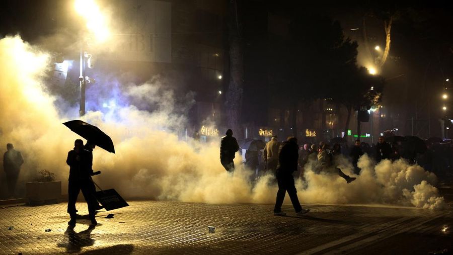 Seorang demonstran menyalakan kembang api di luar kantor Perdana Menteri selama protes anti-pemerintah yang dipicu oleh penyelidikan korupsi terhadap Wakil Perdana Menteri Belinda Balluku, di Tirana, Albania, 24 Januari 2026. (REUTERS/Florion Goga)