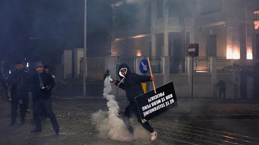 Seorang demonstran menyalakan kembang api di luar kantor Perdana Menteri selama protes anti-pemerintah yang dipicu oleh penyelidikan korupsi terhadap Wakil Perdana Menteri Belinda Balluku, di Tirana, Albania, 24 Januari 2026. (REUTERS/Florion Goga)