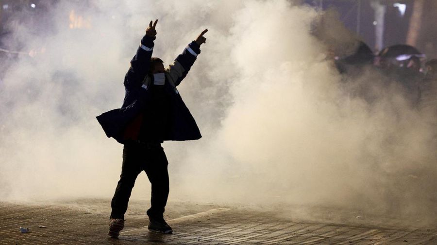 Seorang demonstran menyalakan kembang api di luar kantor Perdana Menteri selama protes anti-pemerintah yang dipicu oleh penyelidikan korupsi terhadap Wakil Perdana Menteri Belinda Balluku, di Tirana, Albania, 24 Januari 2026. (REUTERS/Florion Goga)