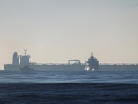 Siluet kapal angkatan laut Prancis yang mengelilingi kapal tanker minyak GRINCH, yang dicegat oleh Prancis di Laut Alboran karena dicurigai beroperasi dengan bendera palsu dan merupakan bagian dari armada bayangan Rusia yang memungkinkan Rusia mengek
