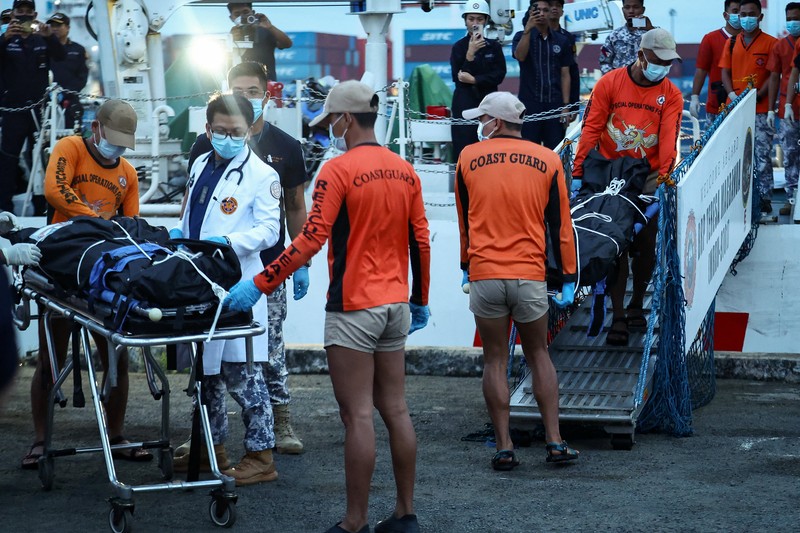 Personel Penjaga Pantai Filipina membawa kantong jenazah berisi sisa-sisa anggota kru yang tewas dalam tenggelamnya kapal kargo M/V Devon Bay, di Pelabuhan Manila, Filipina, 26 Januari 2026. (REUTERS/Eloisa Lopez)