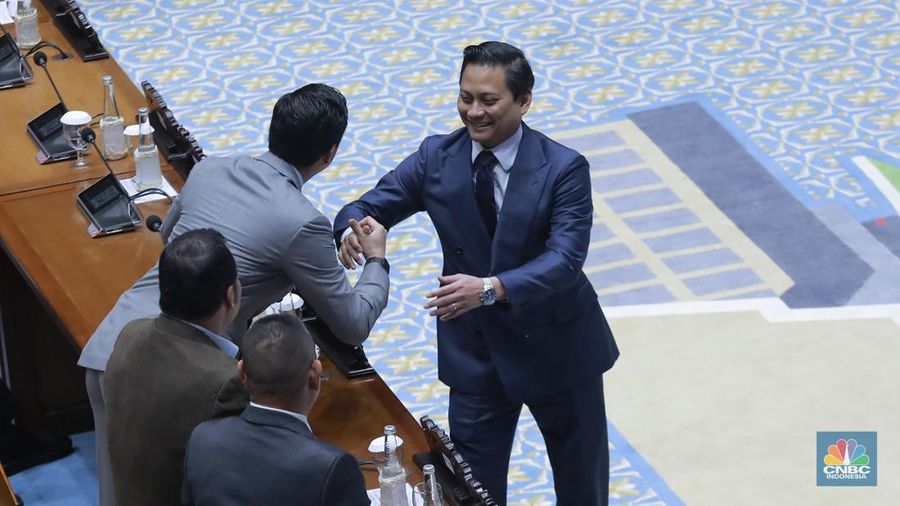 Deputi gubernur Bank Indonesia (BI) Thomas Djiwandono berjabat tangan dengan Wakil Ketua Komisi I DPR yang juga adiknya Budisatrio Djiwandono dalam rapat paripurna DPR, di Gedung DPR, Jakarta, Selasa (27/1/2026). (CNBC Indonesia/Muhammad Sabki)