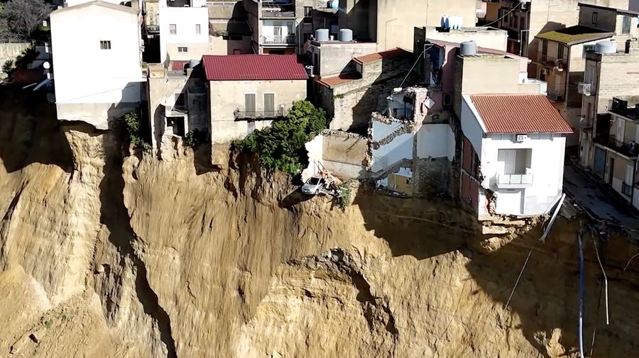 Gambar yang diambil menggunakan drone menunjukkan rumah-rumah yang bertengger di sepanjang tepi tebing setelah tanah longsor di Niscemi, Sisilia, Italia, 27 Januari 2026. (REUTERS/Danilo Arnone)
