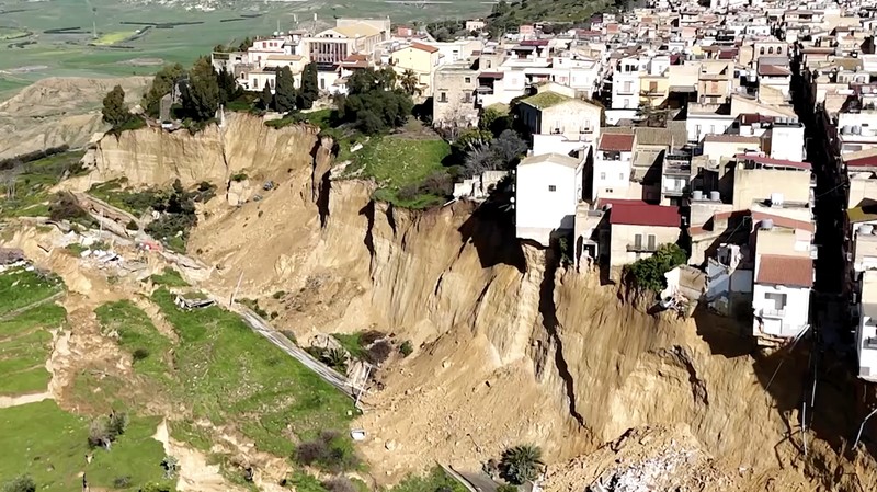 Gambar yang diambil menggunakan drone menunjukkan rumah-rumah yang bertengger di sepanjang tepi tebing setelah tanah longsor di Niscemi, Sisilia, Italia, 27 Januari 2026. (REUTERS/Danilo Arnone)