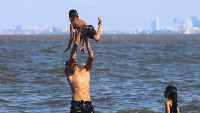 Orang-orang menikmati hari di sungai Rio de la Plata di tengah gelombang panas, di San Isidro, di pinggiran Buenos Aires, Argentina, 27 Januari 2026. (REUTERS/Matias Baglietto)