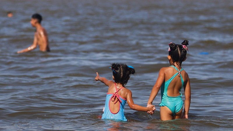 Orang-orang menikmati hari di sungai Rio de la Plata di tengah gelombang panas, di San Isidro, di pinggiran Buenos Aires, Argentina, 27 Januari 2026. (REUTERS/Matias Baglietto)