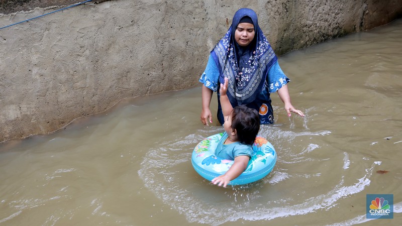 Aktifitas warga saat banjir melanda di kawasan Jalan Cipinang Bali IV, Kelurahan Cipinang Muara, Kecamatan Jatinegara, Jakarta Timur, Kamis, (29/1/2026). (CNBC Indonesia/Muhammad Sabki)