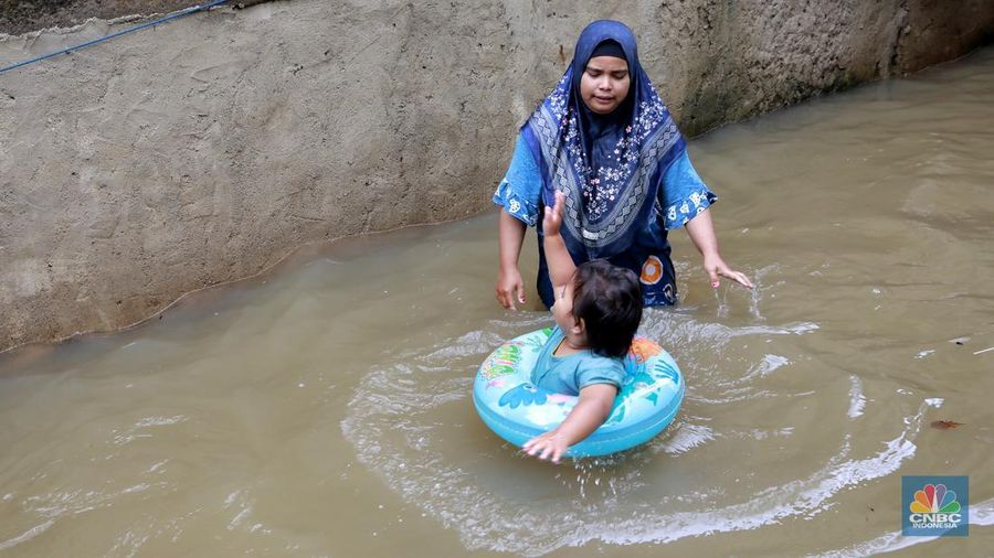 Aktifitas warga saat banjir melanda di kawasan Jalan Cipinang Bali IV, Kelurahan Cipinang Muara, Kecamatan Jatinegara, Jakarta Timur, Kamis, (29/1/2026). (CNBC Indonesia/Muhammad Sabki)