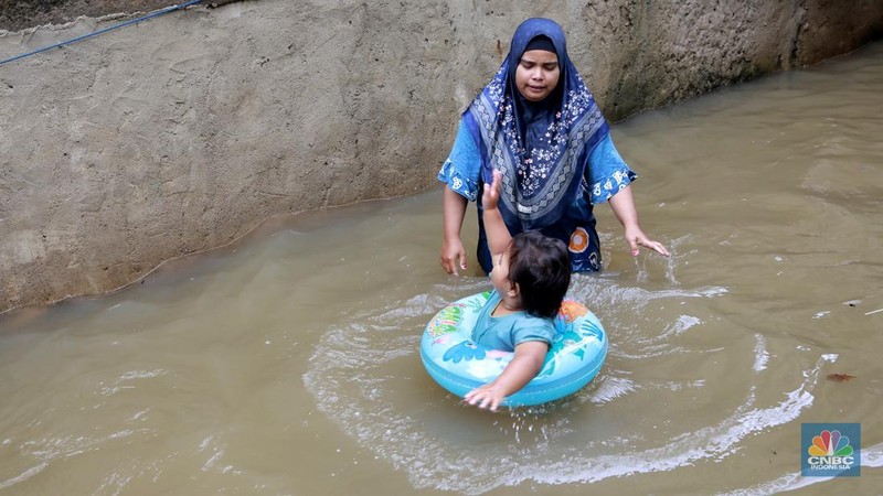 Aktifitas warga saat banjir melanda di kawasan Jalan Cipinang Bali IV, Kelurahan Cipinang Muara, Kecamatan Jatinegara, Jakarta Timur, Kamis, (29/1/2026). (CNBC Indonesia/Muhammad Sabki)