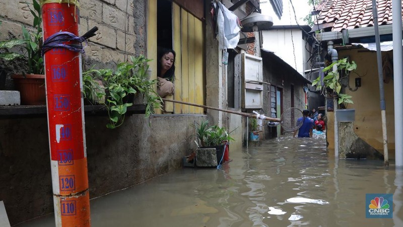 Aktifitas warga saat banjir melanda di kawasan Jalan Cipinang Bali IV, Kelurahan Cipinang Muara, Kecamatan Jatinegara, Jakarta Timur, Kamis, (29/1/2026). (CNBC Indonesia/Muhammad Sabki)