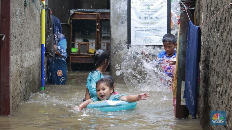 Aktifitas warga saat banjir melanda di kawasan Jalan Cipinang Bali IV, Kelurahan Cipinang Muara, Kecamatan Jatinegara, Jakarta Timur, Kamis, (29/1/2026). (CNBC Indonesia/Muhammad Sabki)